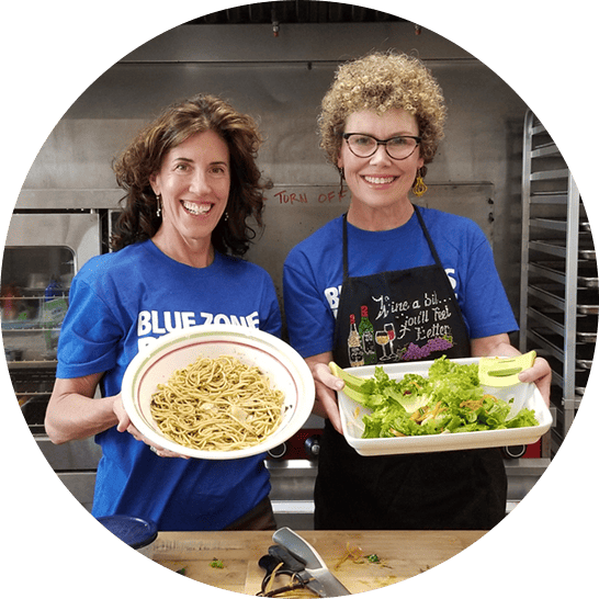 Two women showing their plant-slant dishes.